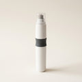 Slim white cordless pet nail grinder standing upright, with grey grip band, rotating grinding head and clear guard cap