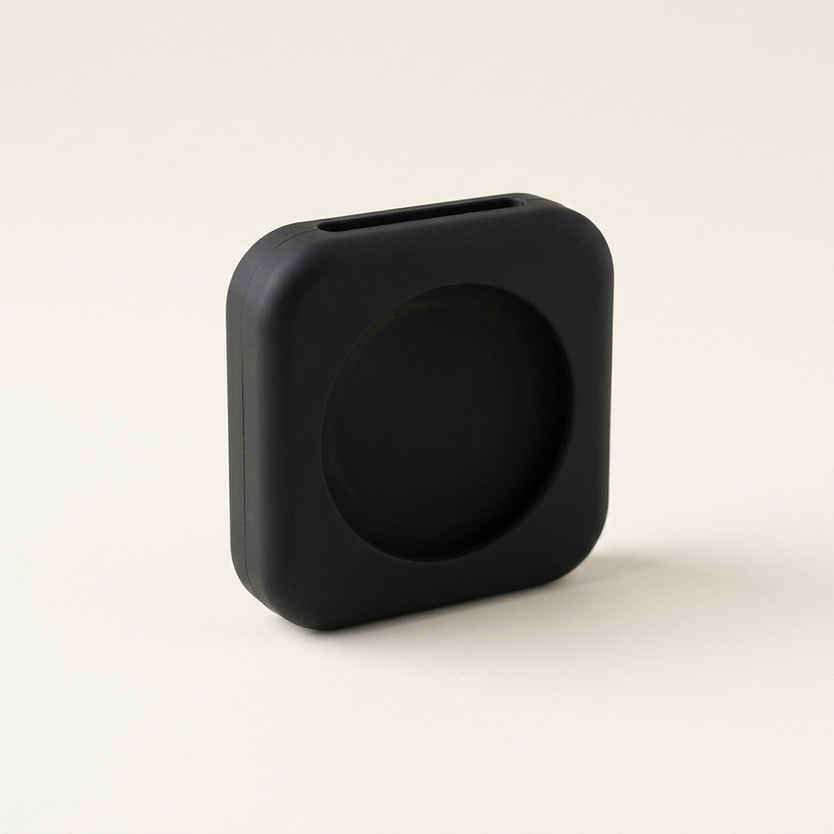 Matte black one-piece silicone AirTag holder for pet collars, showing the circular recess and collar strap slot