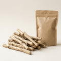Pile of ten natural dried silvervine chew sticks with rough tan bark, beside a kraft paper pouch